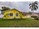 Charming yellow single-story home featuring a one-car garage and well-maintained front yard at 10051 82Nd Ln, Seminole, FL 33777