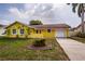 Charming yellow single-story home featuring a one-car garage and well-maintained front yard at 10051 82Nd Ln, Seminole, FL 33777