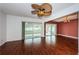 Spacious living room with hardwood floors, ceiling fan, and sliding glass door to Florida room at 10051 82Nd Ln, Seminole, FL 33777