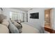 Bright main bedroom featuring a mounted television, mirrored closet doors, and an en-suite bathroom at 10051 82Nd Ln, Seminole, FL 33777