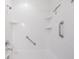 Clean shower featuring grab bars, built-in shelves, and a handheld sprayer, offering accessibility and convenience at 10051 82Nd Ln, Seminole, FL 33777
