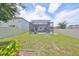 Landscaped backyard with a screened patio, privacy fence, and green grass at 10202 White Linen Ave, Riverview, FL 33578