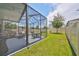 View of the screened in patio with a basketball hoop in the backyard at 10202 White Linen Ave, Riverview, FL 33578
