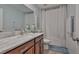 Well-lit bathroom with marble countertops, dark wood cabinets, and shower/tub combo at 10202 White Linen Ave, Riverview, FL 33578