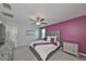 Bedroom with a purple accent wall, plush carpeting, ceiling fan, and a large window providing natural light at 10202 White Linen Ave, Riverview, FL 33578