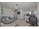 Bright living area with gray walls, carpeted floor, ceiling fan, and a comfortable gray sectional couch at 10202 White Linen Ave, Riverview, FL 33578