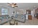 Bright living room with tile floors, ceiling fan, and furniture, open to the kitchen area at 10202 White Linen Ave, Riverview, FL 33578