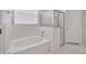 Bright bathroom featuring a soaking tub and a glass shower with white tile and floors at 10819 Newbridge Dr, Riverview, FL 33579