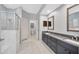 Modern bathroom featuring a double sink vanity, tiled floors, and a glass door shower at 10819 Newbridge Dr, Riverview, FL 33579