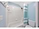 Bright bathroom featuring white tiles, blue walls and a shower tub combo at 10819 Newbridge Dr, Riverview, FL 33579