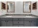 Close-up of modern double sink vanity featuring gray cabinets, mirrors, and shelving at 10819 Newbridge Dr, Riverview, FL 33579