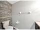 Bathroom showcasing a toilet and horizontally laid wooden panel accent wall at 10819 Newbridge Dr, Riverview, FL 33579