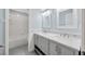Light blue bathroom with double sinks, marble countertop, and tub shower combo at 10819 Newbridge Dr, Riverview, FL 33579