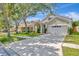 Exterior view of home with well-manicured lawn, attractive landscaping, and a two-car garage at 10819 Newbridge Dr, Riverview, FL 33579