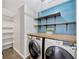 Well-organized laundry room features a wood countertop, open shelving, and blue accent wall at 10819 Newbridge Dr, Riverview, FL 33579