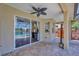 Covered outdoor patio featuring stone pavers, ceiling fan, and view of pool and pond at 10819 Newbridge Dr, Riverview, FL 33579