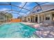 Beautiful pool with a screened-in enclosure and a stone fire pit for outdoor relaxation at 10819 Newbridge Dr, Riverview, FL 33579