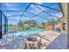 View of screened pool with lake view, patio and fire pit at 10819 Newbridge Dr, Riverview, FL 33579