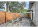 Cozy backyard patio area, featuring four gray chairs, a small table, and a partial wood fence at 1145 53Rd N Ave, St Petersburg, FL 33703