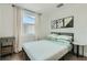 Inviting bedroom showcasing a comfortable bed, wood flooring, and large window with sheer curtains at 1145 53Rd N Ave, St Petersburg, FL 33703