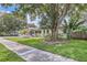 Charming single-story home with lush landscaping, mature trees, and a well-manicured lawn at 1145 53Rd N Ave, St Petersburg, FL 33703