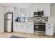 Contemporary kitchen featuring white cabinetry, stainless steel appliances, mosaic tile backsplash, and natural light at 1145 53Rd N Ave, St Petersburg, FL 33703