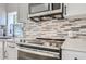 Modern kitchen features a stainless steel oven, range, and gray backsplash at 1145 53Rd N Ave, St Petersburg, FL 33703