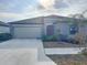 Inviting home with a two-car garage, red front door, and well-kept landscaping at 11524 Sage Canyon Dr, Riverview, FL 33578