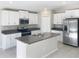 Bright kitchen with white cabinets, granite countertops, stainless steel appliances, and center island with a sink at 11524 Sage Canyon Dr, Riverview, FL 33578