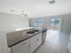 Open layout showcasing a kitchen island with stainless steel sink and sliding door with lake views at 11524 Sage Canyon Dr, Riverview, FL 33578