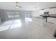 Bright and airy living room with tile floors, a kitchen island, and sliding glass doors leading to the patio at 11524 Sage Canyon Dr, Riverview, FL 33578