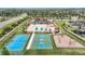 Aerial view displaying the tennis and basketball courts, swimming pool, clubhouse, and playground at 12687 Retreat Pl, Spring Hill, FL 34610