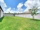 A lush green backyard with well-maintained lawn and a white vinyl privacy fence at 12687 Retreat Pl, Spring Hill, FL 34610