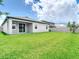 Large grassy backyard featuring privacy fence and view of the home's patio area at 12687 Retreat Pl, Spring Hill, FL 34610