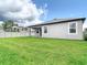 Spacious backyard with plush green grass, white fence, and covered back patio at 12687 Retreat Pl, Spring Hill, FL 34610