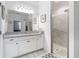 Bathroom with a granite countertop, a glass-enclosed shower, a large mirror, and modern fixtures at 12687 Retreat Pl, Spring Hill, FL 34610