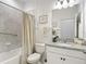 Well-lit bathroom features a shower with curtain, granite countertop, and vanity, providing functionality and comfort at 12687 Retreat Pl, Spring Hill, FL 34610