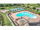 Aerial view of the community pool with lounge seating, basketball court, and tennis courts at 12687 Retreat Pl, Spring Hill, FL 34610