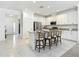 Open kitchen with granite countertops, white cabinets, and seating at 12687 Retreat Pl, Spring Hill, FL 34610