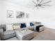 Spacious living area featuring a gray sectional sofa, stylish decor, and modern ceiling fan at 12687 Retreat Pl, Spring Hill, FL 34610