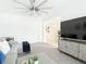 Open-concept living room with a gray sectional sofa, modern TV console, and neutral color palette at 12687 Retreat Pl, Spring Hill, FL 34610