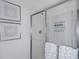 Clean glass shower with motivational quote, framed art and white towels at 13548 Tropical Breeze Way, Hudson, FL 34669