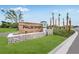 Landscaped Palm Wind entrance sign with stone base and wood paneling at 13548 Tropical Breeze Way, Hudson, FL 34669