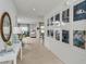Bright and spacious hallway featuring modern decor, artwork, and views into the living areas at 13548 Tropical Breeze Way, Hudson, FL 34669