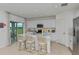 Bright, all-white kitchen with stainless steel appliances, a large island, and sliding glass doors to the backyard at 13548 Tropical Breeze Way, Hudson, FL 34669