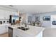 Open concept kitchen with stainless steel appliances and an island, seamlessly flowing into the dining and living area at 13548 Tropical Breeze Way, Hudson, FL 34669