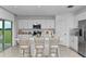 Modern kitchen with white cabinets, stainless steel appliances, and a spacious island with seating at 13548 Tropical Breeze Way, Hudson, FL 34669