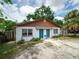 Charming duplex featuring bright blue doors, a symmetrical design, and a welcoming front yard at 1406 E Holland Ave, Tampa, FL 33612
