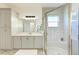 Well-lit bathroom with shower, grey cabinets, full-length mirror, and a neutral color palette throughout at 15525 Corona Del Mar Dr, Wimauma, FL 33598