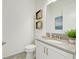 Modern powder room with granite countertop, toilet, sink, and a neutral color palette throughout at 15525 Corona Del Mar Dr, Wimauma, FL 33598